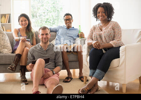 Portrait of group of friends sitting in living room Stock Photo