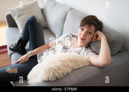 Portrait of smiling woman sitting on sofa Stock Photo