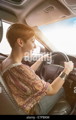 Side view of woman driving car Stock Photo