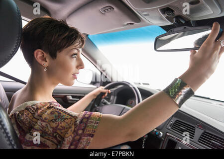 Side view of woman driving car Stock Photo