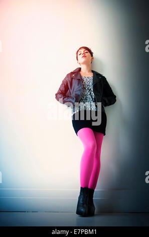Woman wearing leather jacket, mini skirt and ping tights Stock Photo