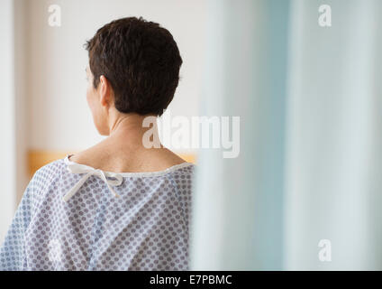 Rear view of senior woman wearing hospital gown Stock Photo