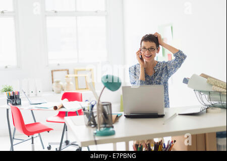 Senior business woman using cell phone in office Stock Photo