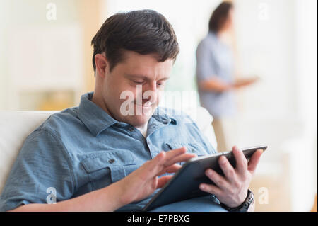 Man with down syndrome using tablet Stock Photo