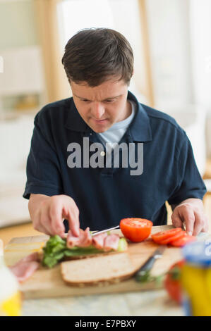 Man with down syndrome making sandwich Stock Photo