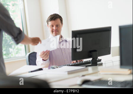 Man with down syndrome working in office Stock Photo