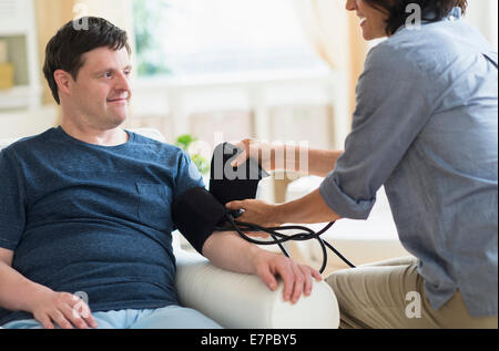 Man with down syndrome having blood pressure measured Stock Photo