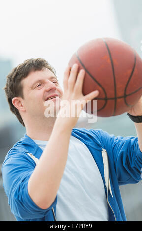 Man with down syndrome playing basketball Stock Photo