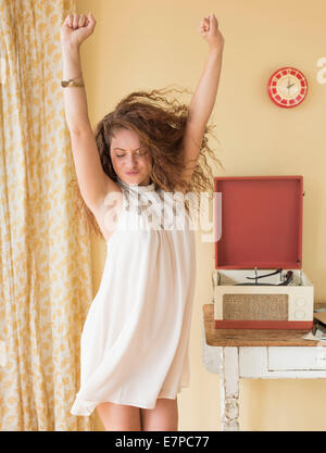 Portrait of woman dancing happily in room Stock Photo