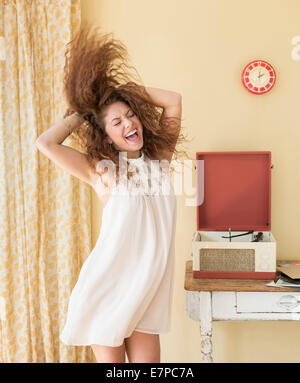 Portrait of woman dancing happily in room Stock Photo