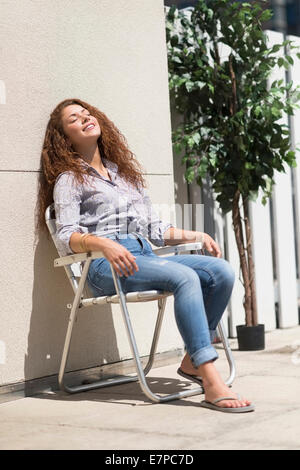 woman relaxing in deck chair outdoors e7pc7d