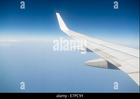 Airplane is flying through the sky without any clouds but with the left wing Stock Photo