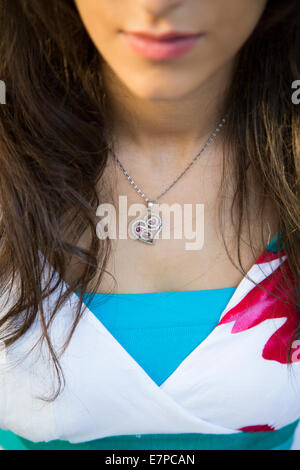 Close up of a young woman wearing a heart shaped necklace Stock Photo