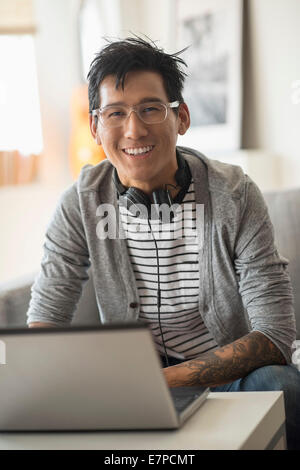 Portrait of man with headphones in front of laptop Stock Photo