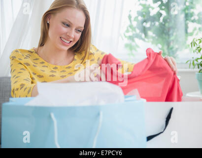 Blond woman looking at new clothing Stock Photo