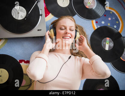 Young woman listening to music on vinyl record Stock Photo