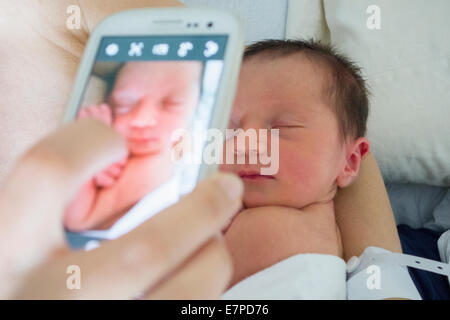 Mother photographing newborn daughter Stock Photo