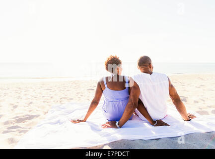 Man and woman sitting on beach Stock Photo
