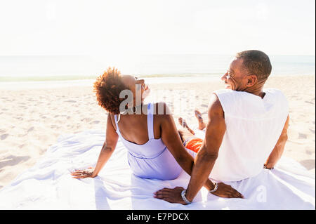 Man and woman sitting on beach Stock Photo