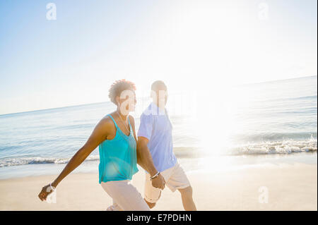 Mature couple walking on beach Stock Photo