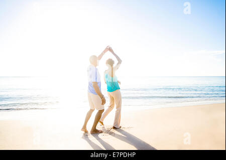 Mature couple dancing on beach Stock Photo