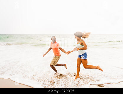 Young couple running on beach Stock Photo