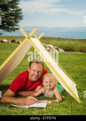 USA, Utah, Garden City, Father and daughter (2-3) playing in tent Stock Photo
