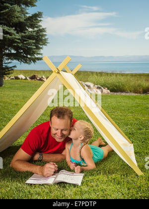 USA, Utah, Garden City, Father and daughter (2-3) playing in tent Stock Photo