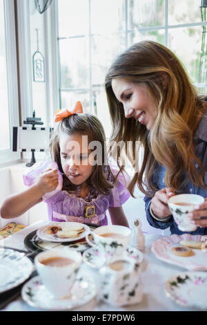 Mother and daughter (4-5) eating together in dining room Stock Photo