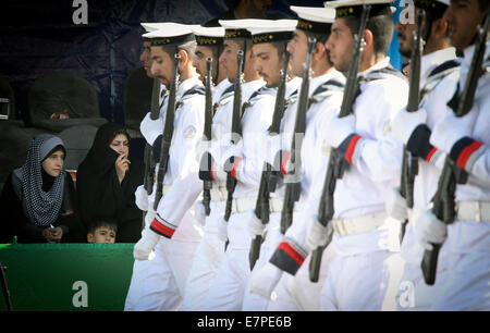 Tehran, Iran. 22nd Sep, 2014. People watch a military parade marking the 34th anniversary of the beginning of the 1980-1988 Iran-Iraq war in Tehran, capital of Iran, on Sept. 22, 2014. Credit:  Ahmad Halabisaz/Xinhua/Alamy Live News Stock Photo