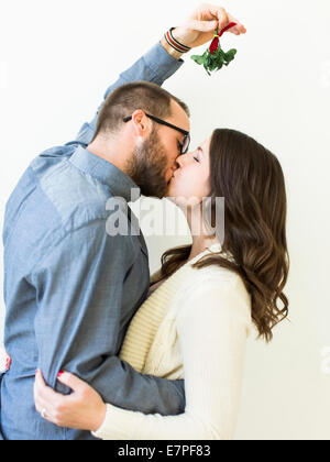 Couple kissing under mistletoe Stock Photo