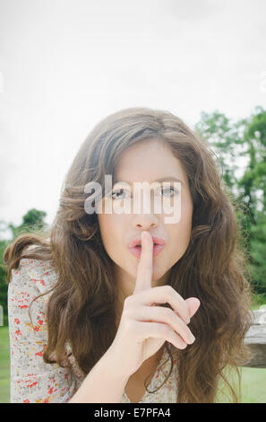 Portrait of woman with finger on lips Stock Photo