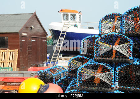 Lobster pots and fishing boat on the Holy Isle of Lindisfarne, Northumbria, in the north of England. Stock Photo