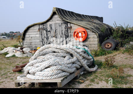 Old upturned Keel Boats now used for storage on the Island of Lindisfarne off of the Northumbrian coast in the north of England. Stock Photo