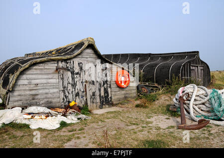 Old upturned Keel Boats now used for storage on the Island of Lindisfarne off of the Northumbrian coast in the north of England. Stock Photo