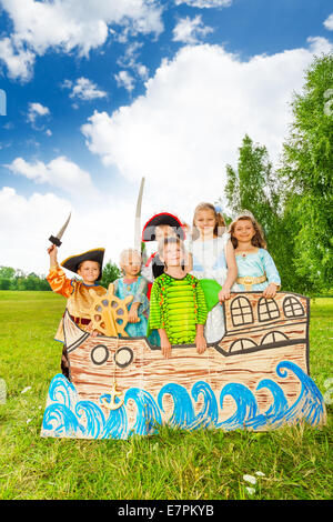 Group of kids in different costumes stand on ship Stock Photo