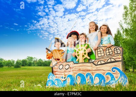 Happy children in costumes standing on ship Stock Photo
