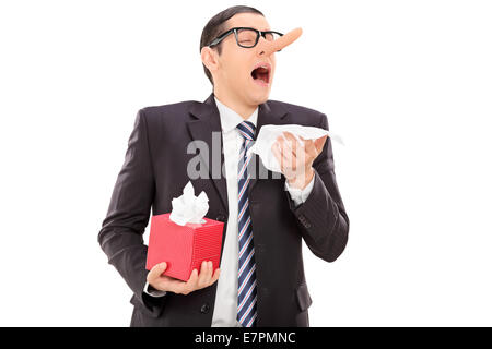 Businessman with a long nose sneezing and holding a napkin Stock Photo