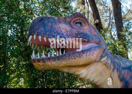 A life size Tyrannosaurus Rex dinosaur figure prowls the forest Stock Photo