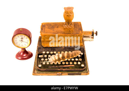 ancient typewriter with old book, feather, wooden owl and clock isolated on white Stock Photo