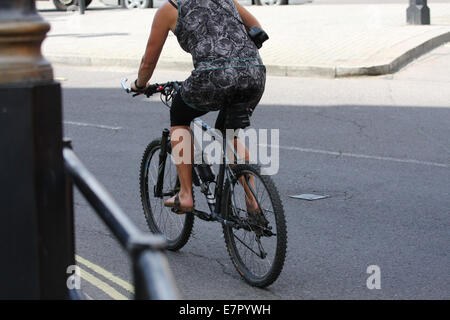 Rear view of a female cyclist exiting the roundabout in Trafalgar Square, London Stock Photo