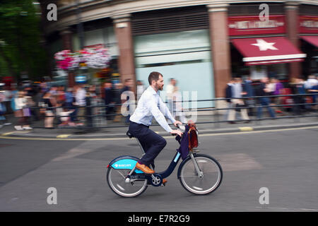 A cyclist riding around the roundabout at Trafalgar Square Stock Photo