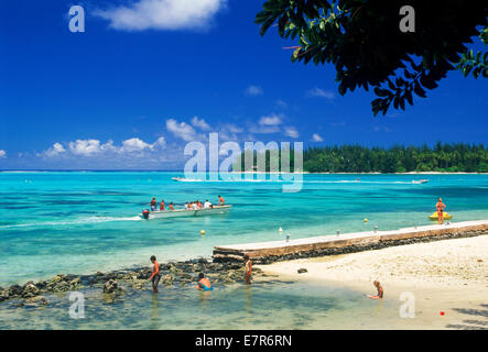 Sandy beaches, outrigger and tourists in front of Hibiscus Hotel on Moorea Island in French Polynesia Stock Photo