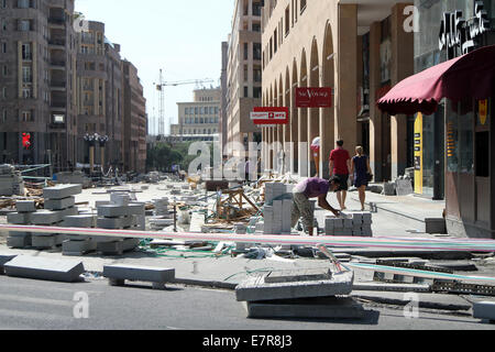 A worker lays paving slabs on Northern Avenue, also known as Hyusisayin Poghota, in central Yerevan, Armenia, Stock Photo