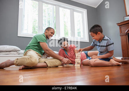 Family on the floor playing a game at home. Stock Photo