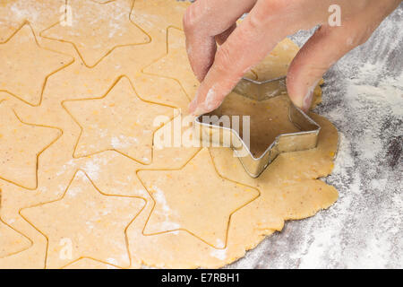 Making gingerbread christmas cookies with metal cutter. Ginger dough and flour Stock Photo