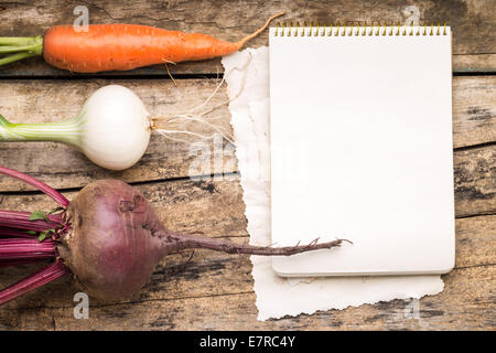 Empty Recipe Card  on Wooden Rustic Background with Fresh Vegetables. Cookbook with roots. Stock Photo