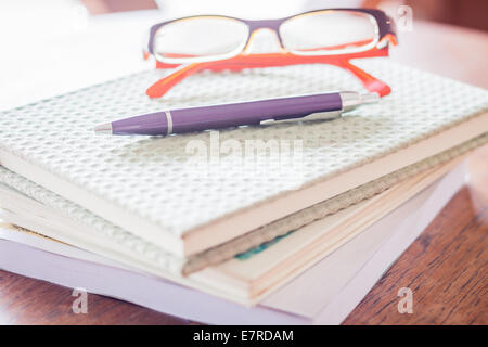 Pen and eyeglasses on three notebooks, stock photo Stock Photo