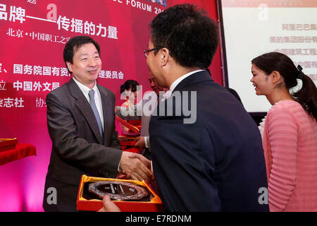 Beijing, China. 23rd Sep, 2014. Zhou Mingwei, president of China Foreign Languages Publishing Administration, presents medals for the Top 50 Chinese enterprises in terms of overseas performance at Chinese Enterprises' Overseas Performance Forum 2014 in Beijing, capital of China, Sept. 23, 2014. Credit:  Zhang Yuwei/Xinhua/Alamy Live News Stock Photo