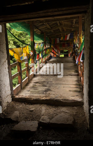 Eastern Bhutan, Trashi Yangtse, prayer flags lining old wooden bridge over Dongdi Chu river Stock Photo